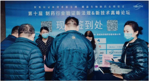 允咨会议协办活动现场，参会者在品牌背景板前交流